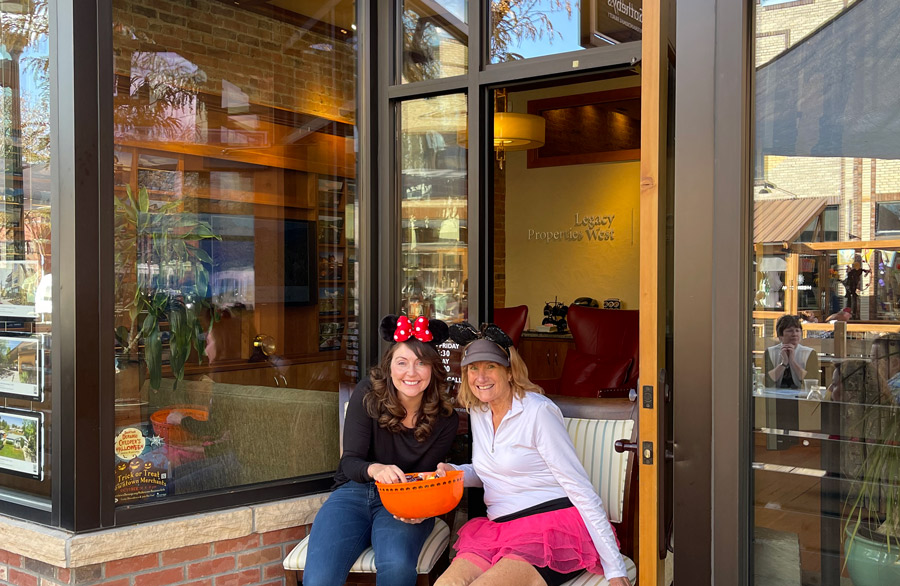 Two ladies sitting outside a storefront