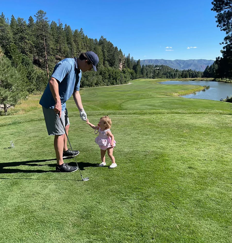 father playing golf with his baby daughter